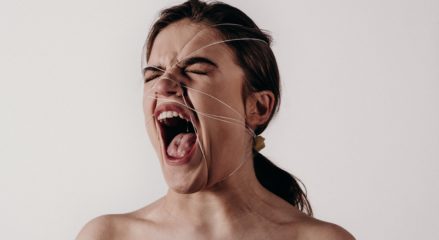 An angry woman with thread around her face