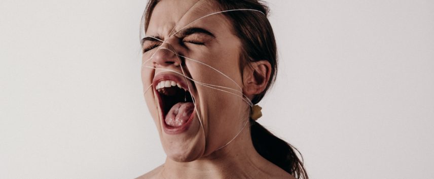 An angry woman with thread around her face
